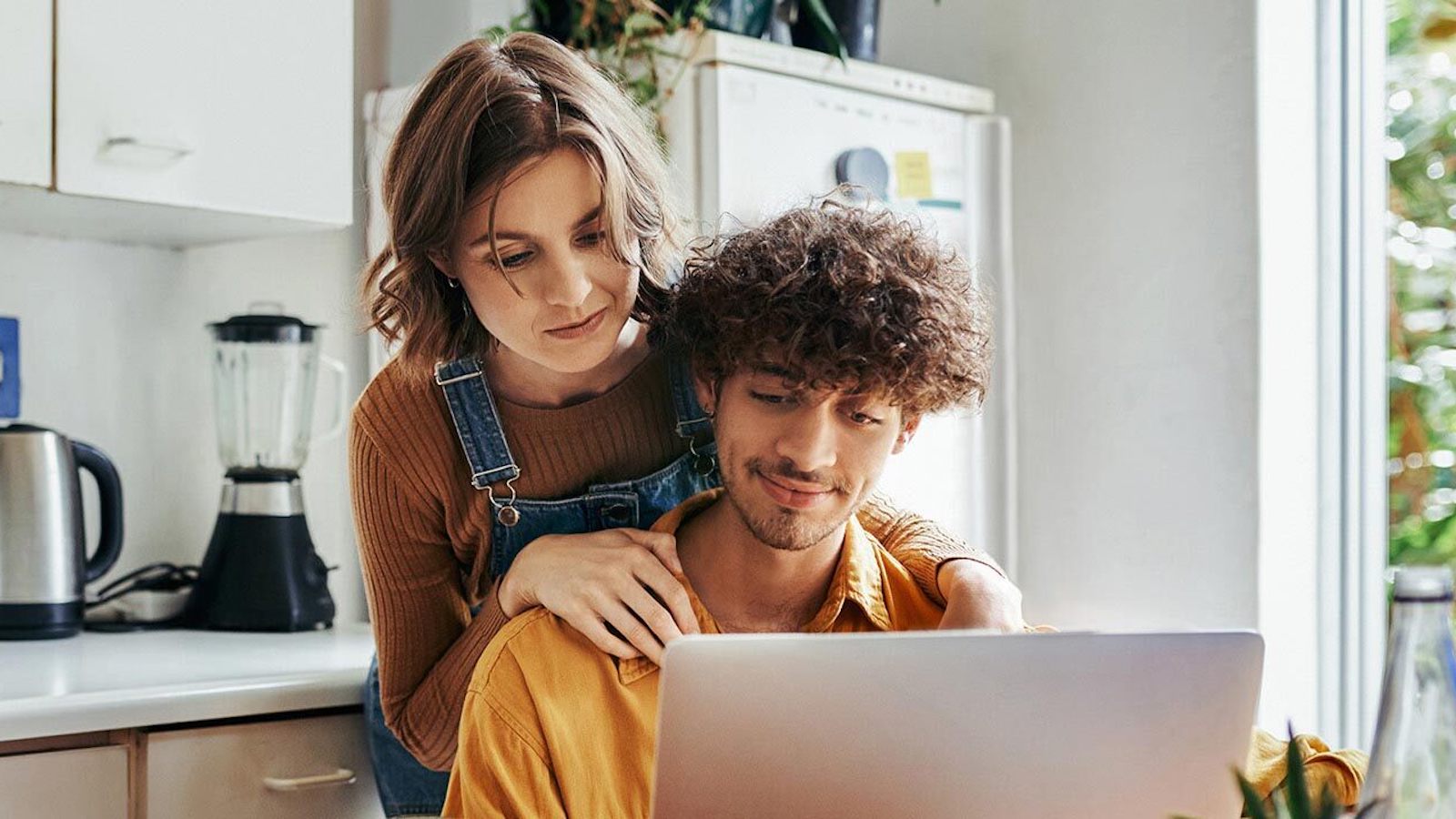 couple in the kitchen looking at their laptop screen